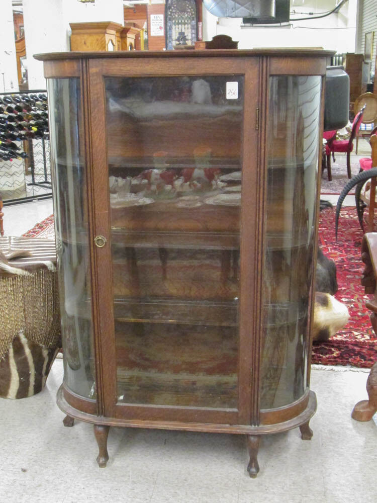 AN OAK AND CURVED GLASS CHINA CABINET, American, c Lot 256