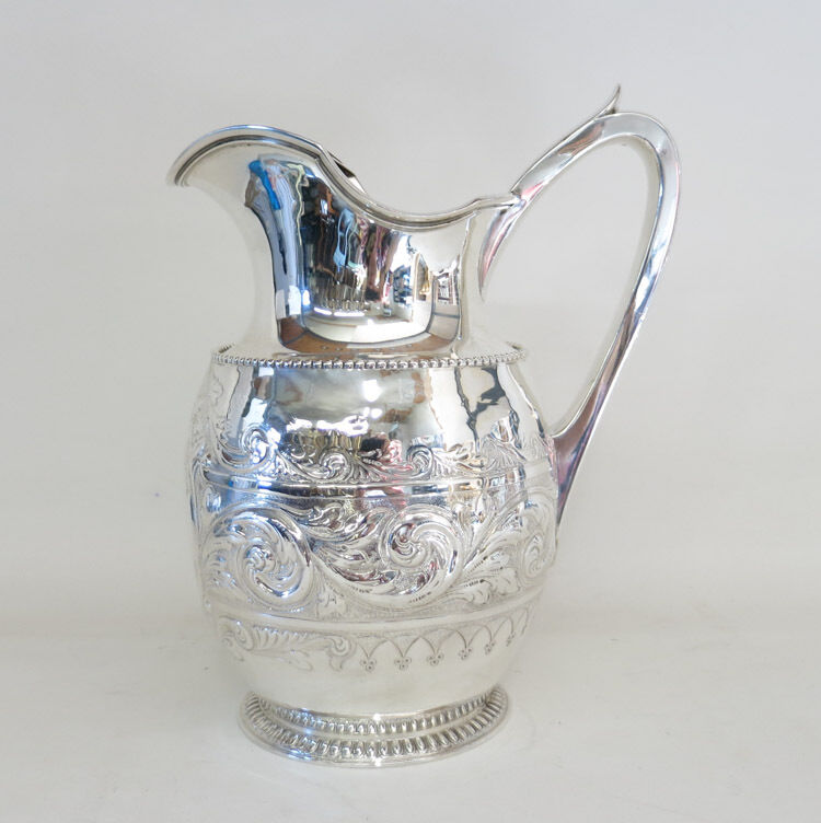 STERLING SILVER WATER PITCHER, with raised scrolli Lot 704