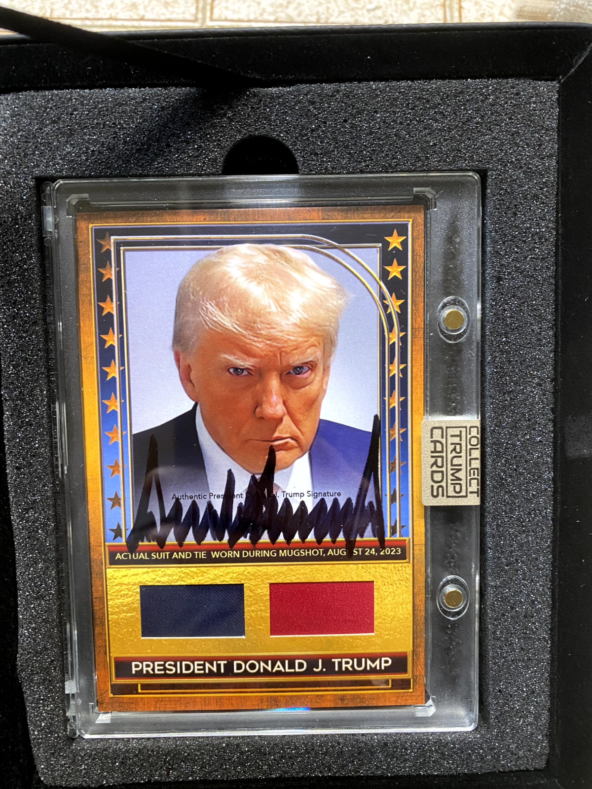Autographed Donald Trump Card with Authentic Piece Of Suit & Tie From Mugshot Autographed Donald Trump Card with Authentic Piece Of Suit & Tie From Mugshot